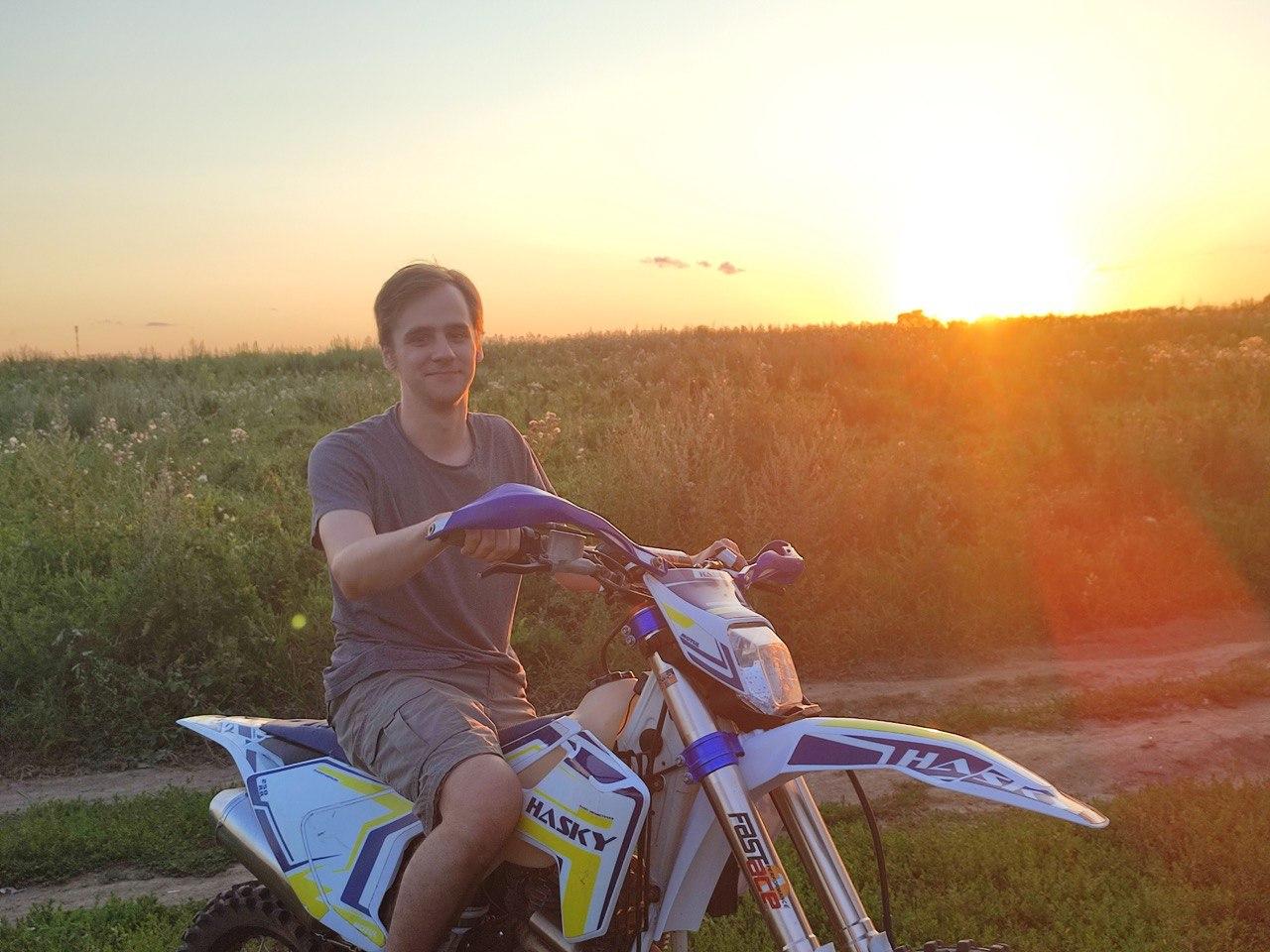 Мобильный разработчик Алексей на мотоцикле на фоне заката