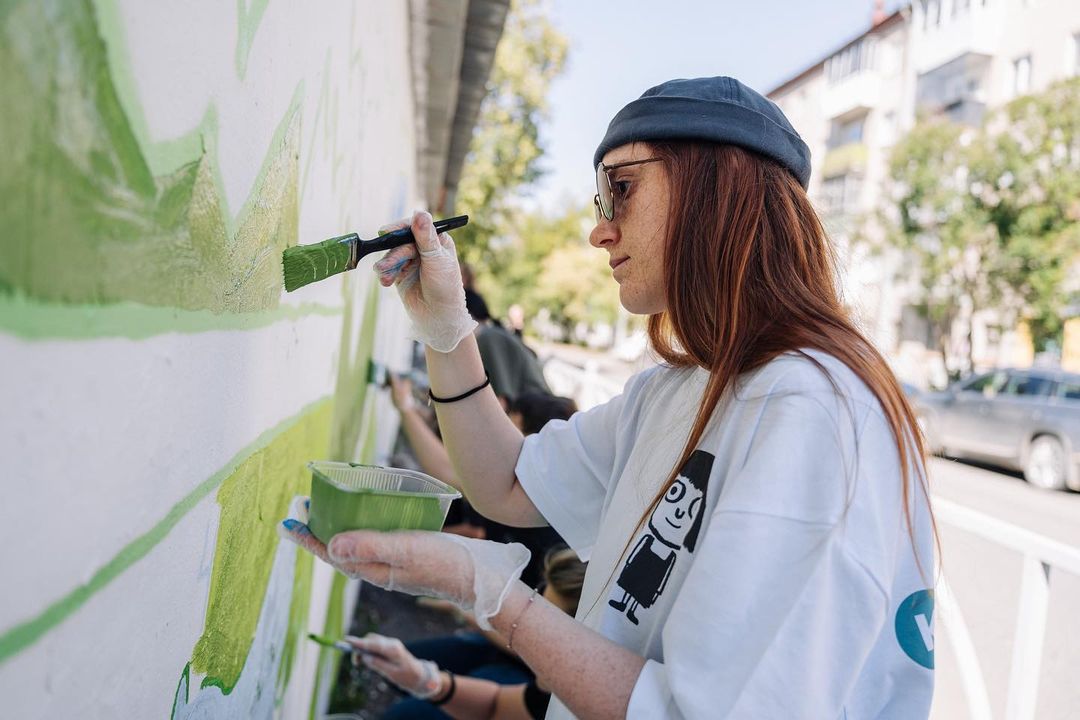 Девушка дизайнер рисует на стене